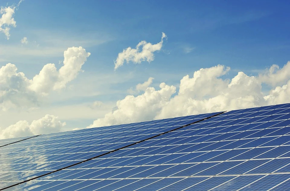 Große Solarthermieanlage, im Hintergrund blauer Himmel mit Wolken und Sonenstrahlen