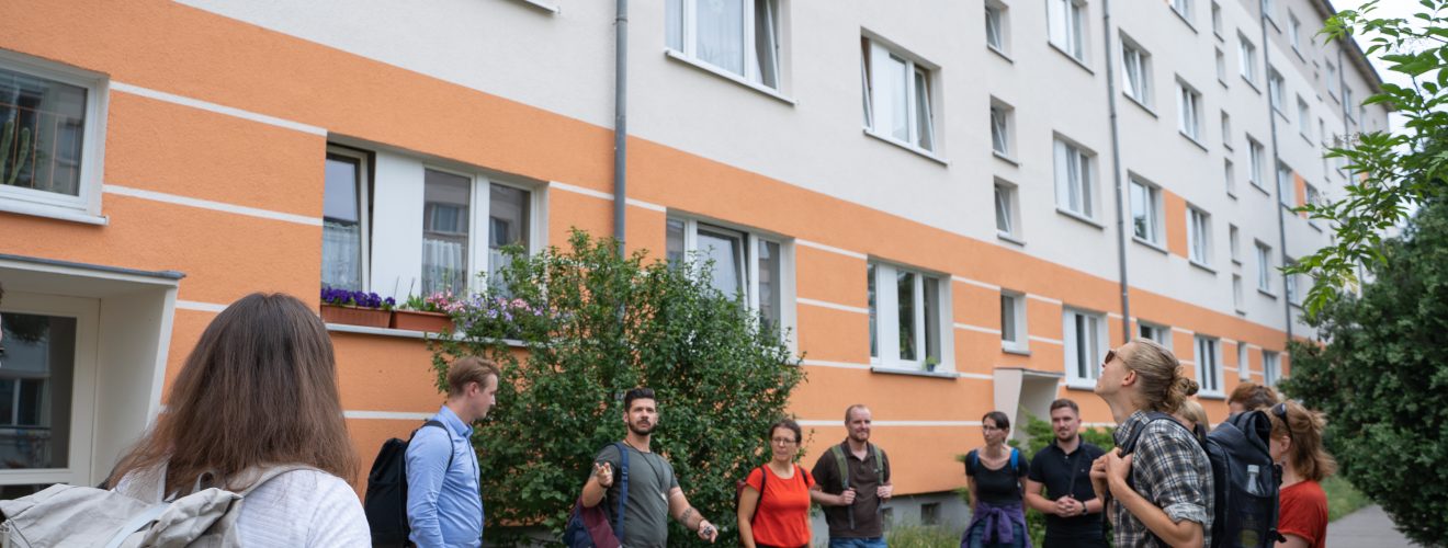Etwa zehn Personen stehen vor einem Gebäude des Dunckerviertels im Kreis, Alexander Peitz (WSL) erklärt etwas
